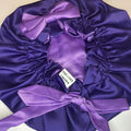 Purple satin bonnet with a bow on a white background